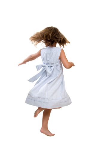 A 4 year old girl twirling and dancing.