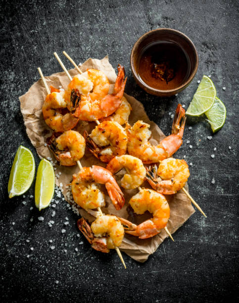 istock Delicious freshly cooked shrimps on skewers. 1155952703