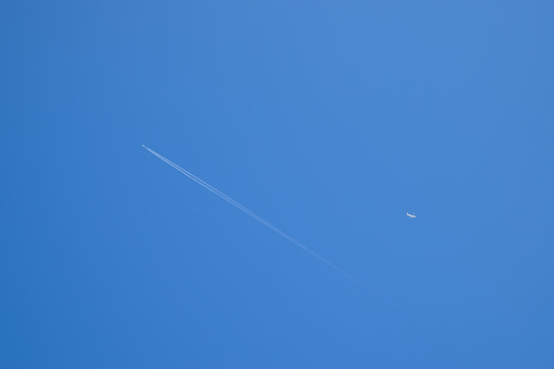 Two passenger aircraft flying nearby. Condensation trail from an airplane in a blue sky.