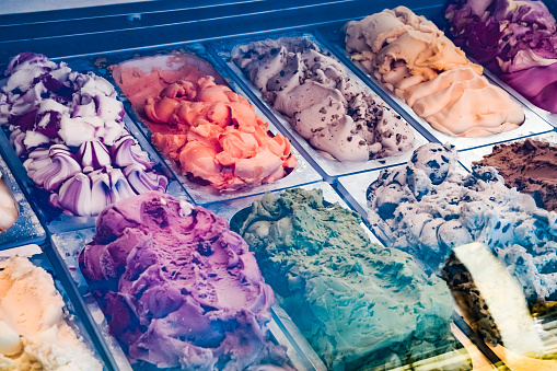 Different sorts of ice cream on the display in the refrigerator.