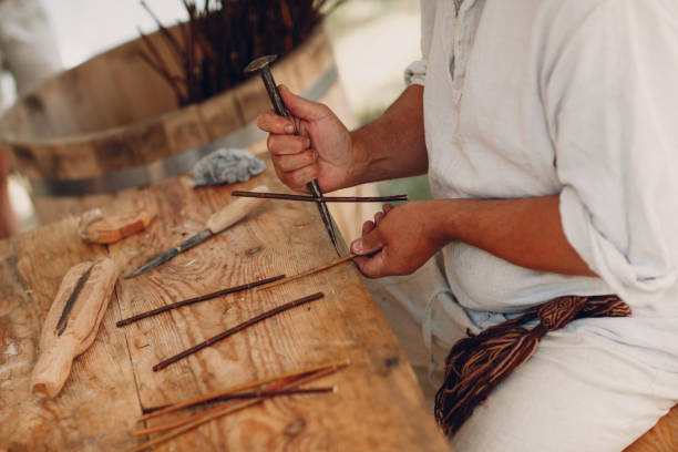 istock Master man weaves a basket of twigs 1155955562