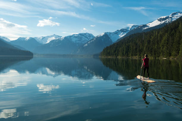 istock Woman exploring a mountain lake by paddleboard 1155958472