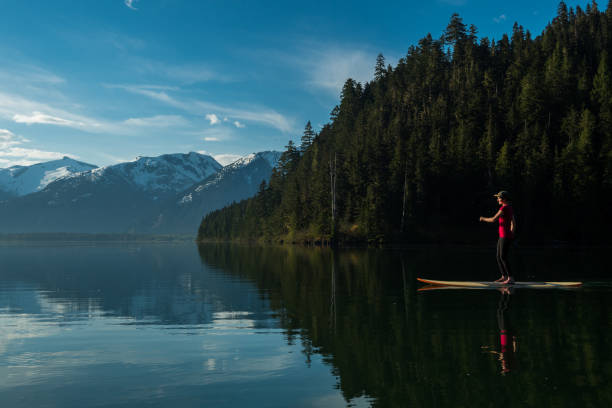 istock Woman exploring a mountain lake by paddleboard 1155958476