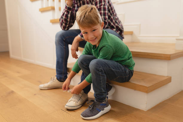 istock Son tying his father shoelaces in a comfortable home 1155959090