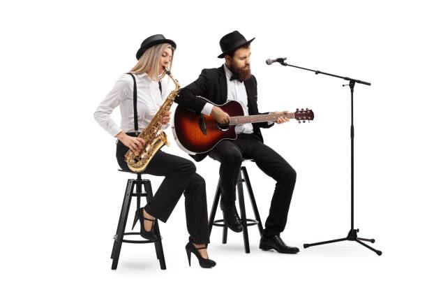 Young woman playing sax and a man playing an acoustic guitar Full length shot of a young woman playing sax and a man playing an acoustic guitar isolated on white background string ensemble stock pictures, royalty-free photos & images