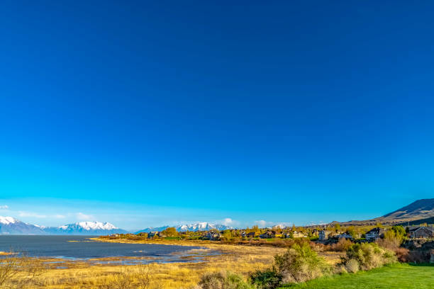 istock Panoramic view of a lake and snow covered mountain under deep blue sky 1155963054