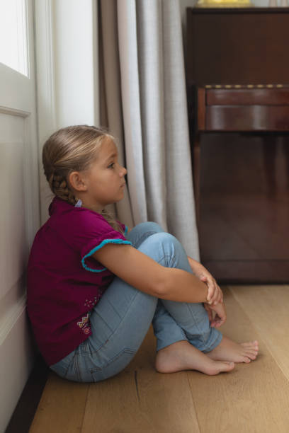 istock Sad girl sitting alone in corner at home 1155964116