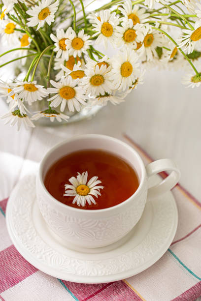 istock Still life with a cup of tea, cookies and daisies 1155966342