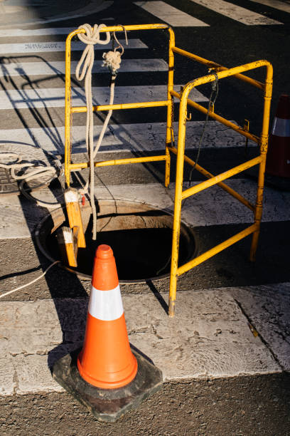 istock Street warning orange construction cone near manhole 1155972801