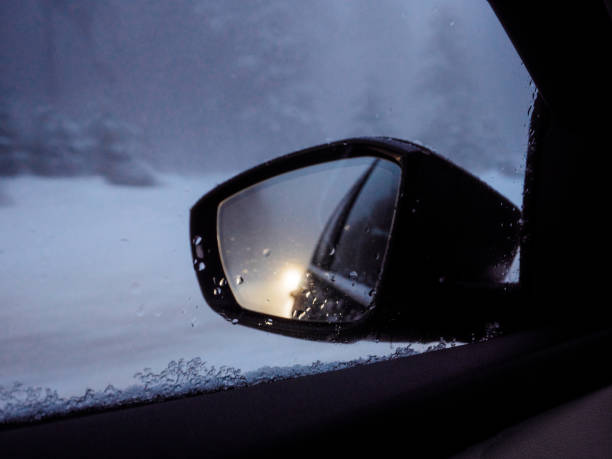 istock Car rear view mirror reflection with snowy road 1155974673