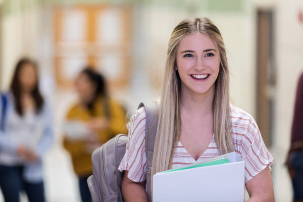 istock Caucasian teen smiles for camera while waiting for friends 1155974955
