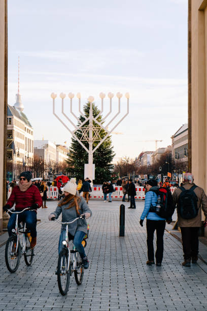 people bicycles hanukkah menorah and christmas tree brandenburg gate berlin - winter city germany brandenburg imagens e fotografias de stock