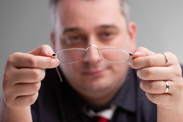 istock Businessman holding a pair of eyeglasses 1155976041