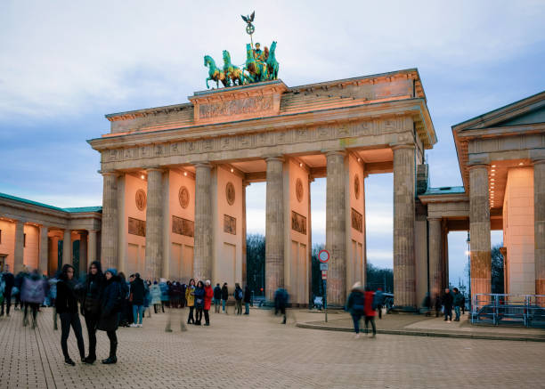 people at brandenburg gate on parizer platz street evening berlin - winter city germany brandenburg imagens e fotografias de stock