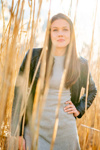 istock Young Woman With Hand on Hip Standing in Tall Dry Grass 1155977892