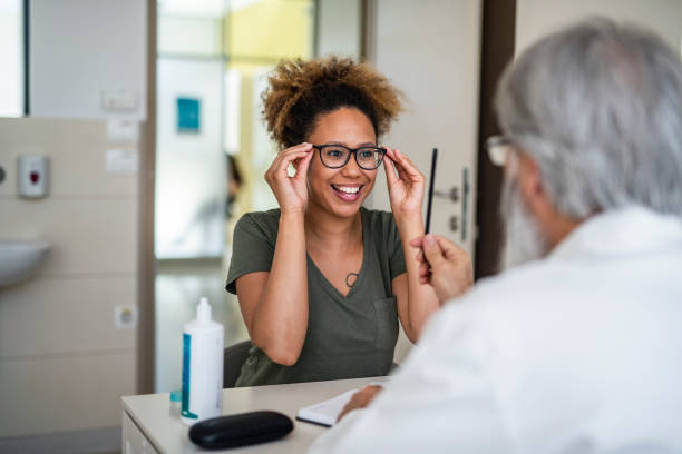 donna che testa i suoi nuovi occhiali nell'ufficio oftalmologia - optometrie foto e immagini stock