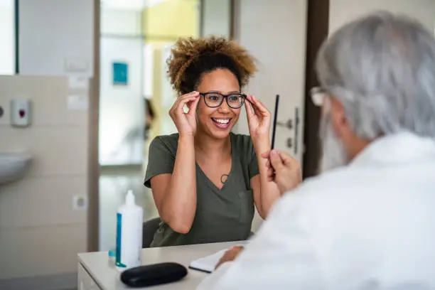 Photo of Woman testing out her new eyeglasses in ophthalmology office