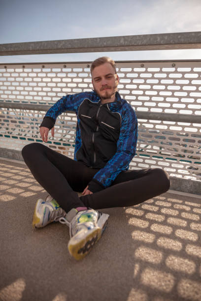 istock one young runner or jogger, sitting on a bridge. 1155980990