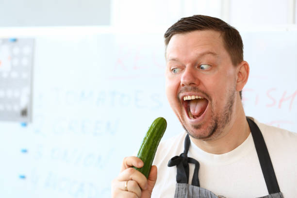 istock Professional Chef Eating Green Organic Cucumber 1155986616