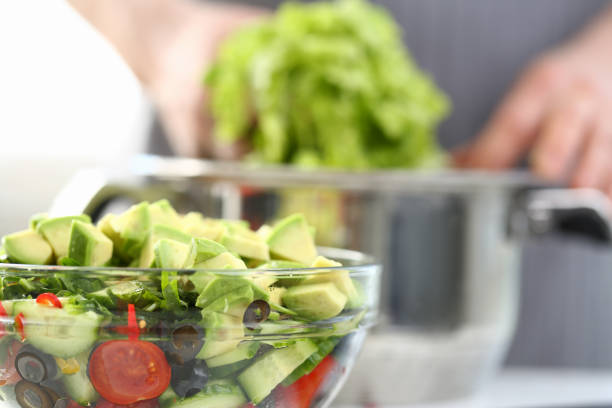 Healthy Chopped Organic Vegetable Avocado Salad. Dieting Food with Tomato, Black Olive and Pieces of Exotic Fruit in Glass Bowl. Delicious Culinary Recipe for Vegan Horizontal View Photography