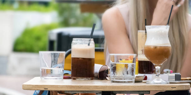 Cold coffee - freddo cappuccino and espresso on a table outdoors at a bar in Greece. Cold coffee - freddo cappuccino and espresso on a table outdoors at a bar in Greece. freddo cappuccino stock pictures, royalty-free photos & images