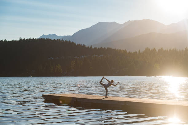 istock Female doing yoga on a mountain lake 1155992929