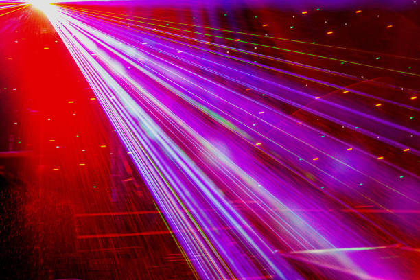 istock Bright nightclub red laser lights cutting through smoke machine smoke making light and rainbow patterns on the dance floor with bokeh in the background. Mardi Gras inspiration 1155997602