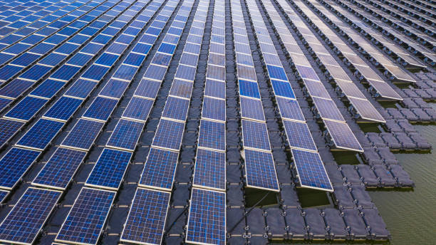 solar panels in aerial view, rows array of polycrystalline silicon solar cells or photovoltaics in solar power plant floating on the water in lake. - polycrystalline imagens e fotografias de stock