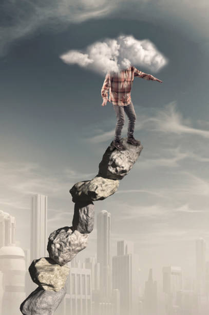 istock Man standing on stack of stones with his head covered by a cloud 1156007887