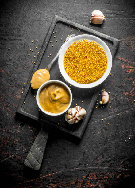 istock Mustard on a cutting Board with garlic cloves. 1156008926