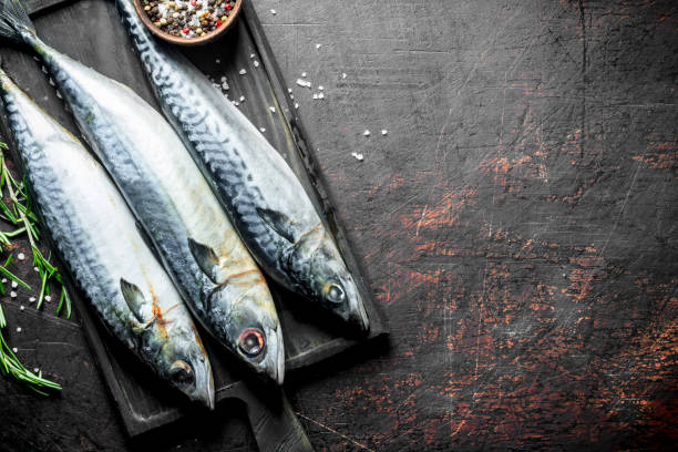 istock Raw fish mackerel on a cutting Board with rosemary and spices. 1156009002