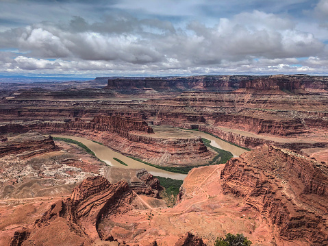 Dead Horse Point is a narrow neck of land surrounded by a deep canyon that drops 2000 feet down to the Colorado River.  This small mesa is where Dead Horse Point gets its name.  According to legend, cowboys who worked on this mesa in the late 1800's often drove herds of feral horses across the mesa to the point where they were corralled in by the sheer cliffs.  On one occasion the wranglers sorted out the best horses and left the others trapped on the point without food or water.  People who found the remains of the horses named the place Dead Horse Point.  Dead Horse Point State Park is in San Juan County near Moab, Utah, USA.