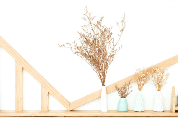 Drying flowers in a vase on the table with white wall background.instragram tone