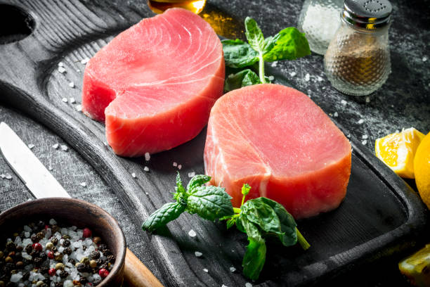 istock Raw tuna steak with herbs and spices. 1156012945