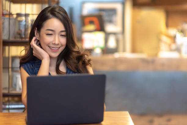 istock Woman making video call with laptop computer at cafe 1156014776
