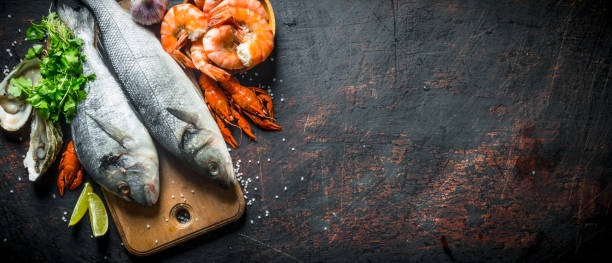 Fresh fish on a cutting Board with oysters, shrimp and crayfish.