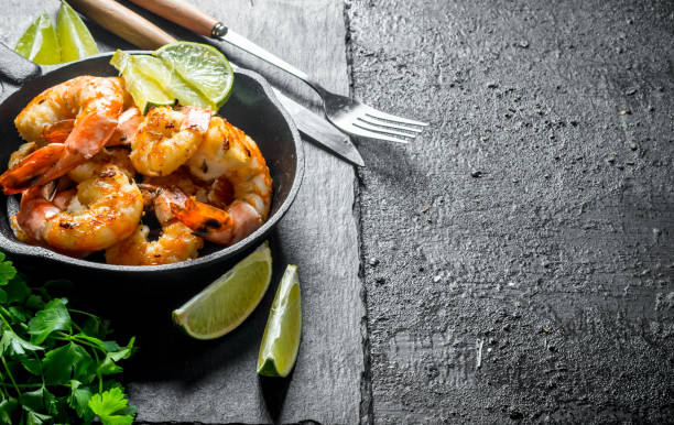 istock Fragrant shrimps on a stone Board with parsley and lime. 1156019554