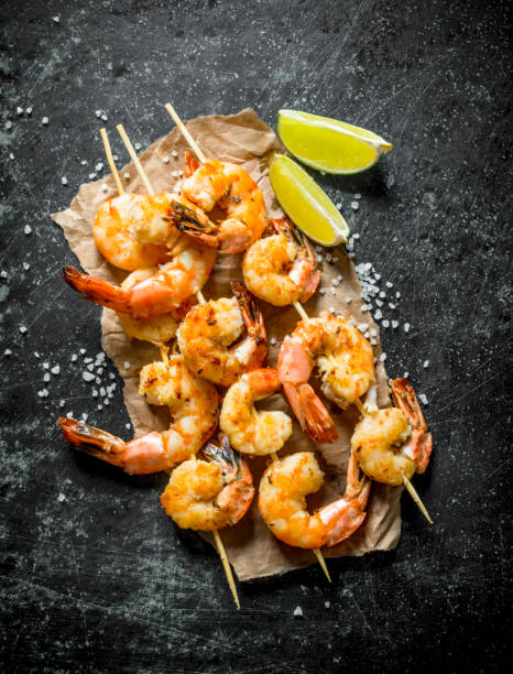 istock Grilled shrimps on paper with the cut lime. 1156019698