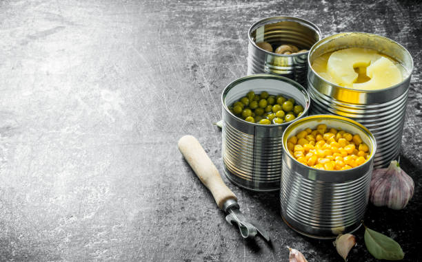 istock Canned pineapples, green peas, corn and mushrooms in open cans. 1156024208