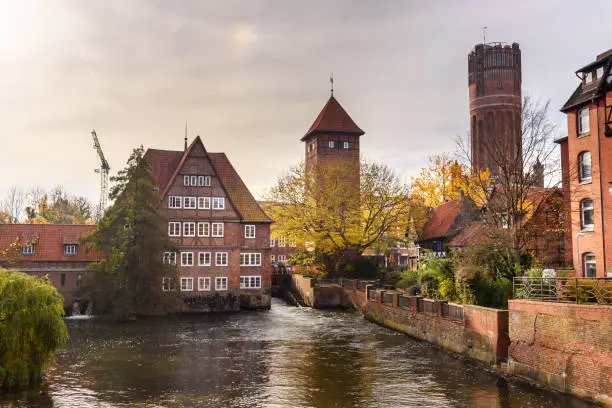 Ratsmuhle or old water mill and Wasserturm or water tower on Ilmenau river at morning in Luneburg. Germany