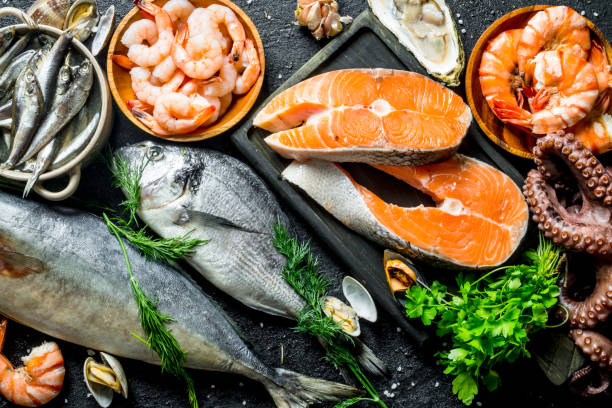 filete de salmón fresco con una variedad de mariscos y hierbas. - crustáceo fotografías e imágenes de stock