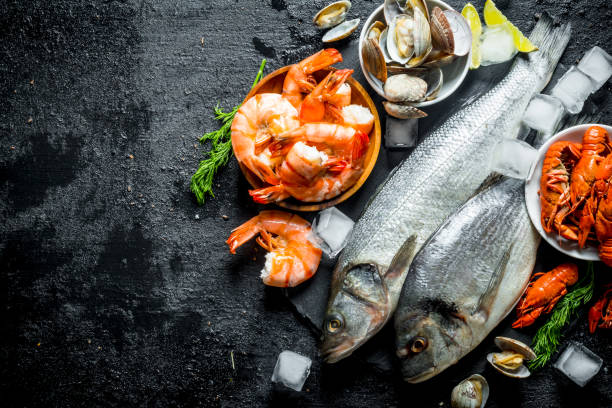 istock Seafood. Fresh fish with shrimp, crayfish and oysters on a stone Board. 1156028035