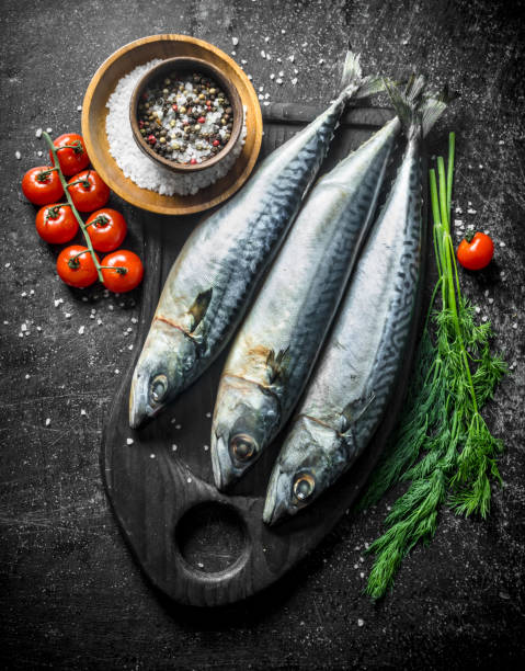 istock Raw mackerel on a cutting Board with dill, spices and tomatoes. 1156028573