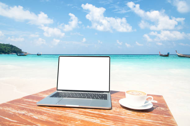 istock Laptop computer and coffee cup on the table at seaside 1156029217