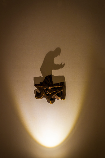 Shadow on the wall in the form of a praying Arab.