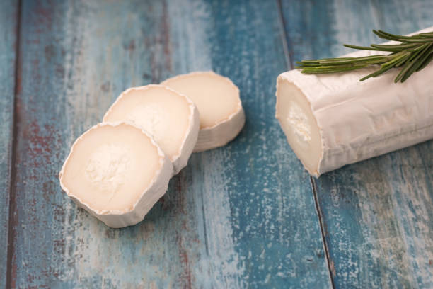 istock Fresh goat cheese with slices on paper. 1156038156