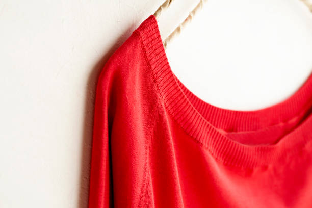 istock a cut sew or knit in red hanging on clothes hanger on white background. 1156040523