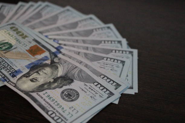 istock Banknotes of one hundred dollars lies on table 1156043815