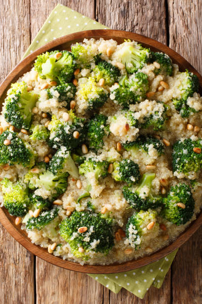 istock Vegetarian broccoli meal with quinoa and pine nuts closeup on a plate. Vertical top view 1156046143