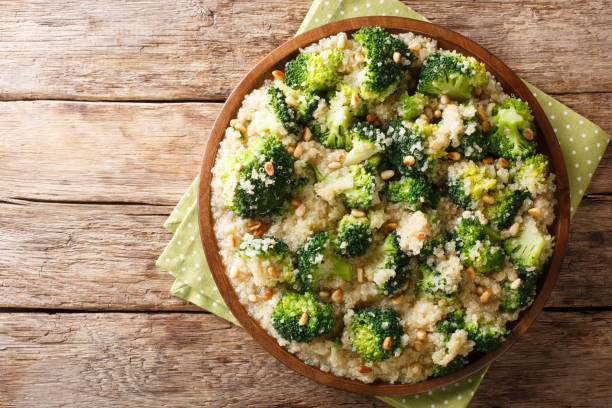 insalata di broccoli con quinoa e pinoli da vicino su un piatto. visualizzazione orizzontale superiore - healthy eating close up lemon nut foto e immagini stock